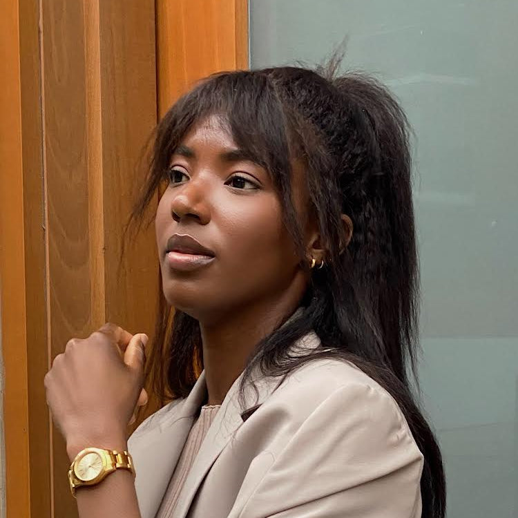 Woman wearing tan jacket and wearing a gold watch