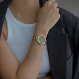 woman wearing gold and green watch