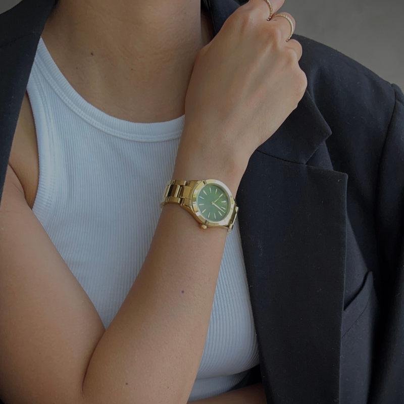 woman wearing gold and green watch
