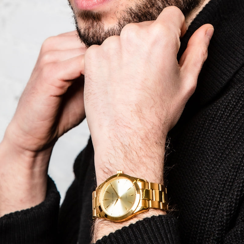 Man wearing a gold stainless steel watch